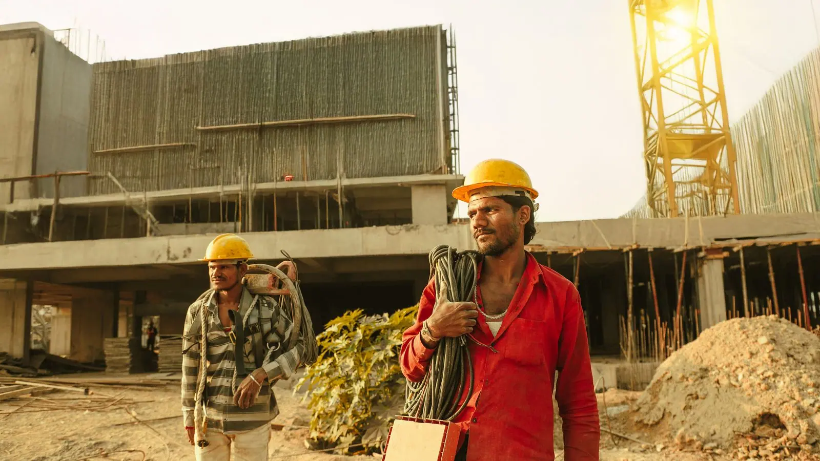Obreros con casco frente a un edificio en construcción