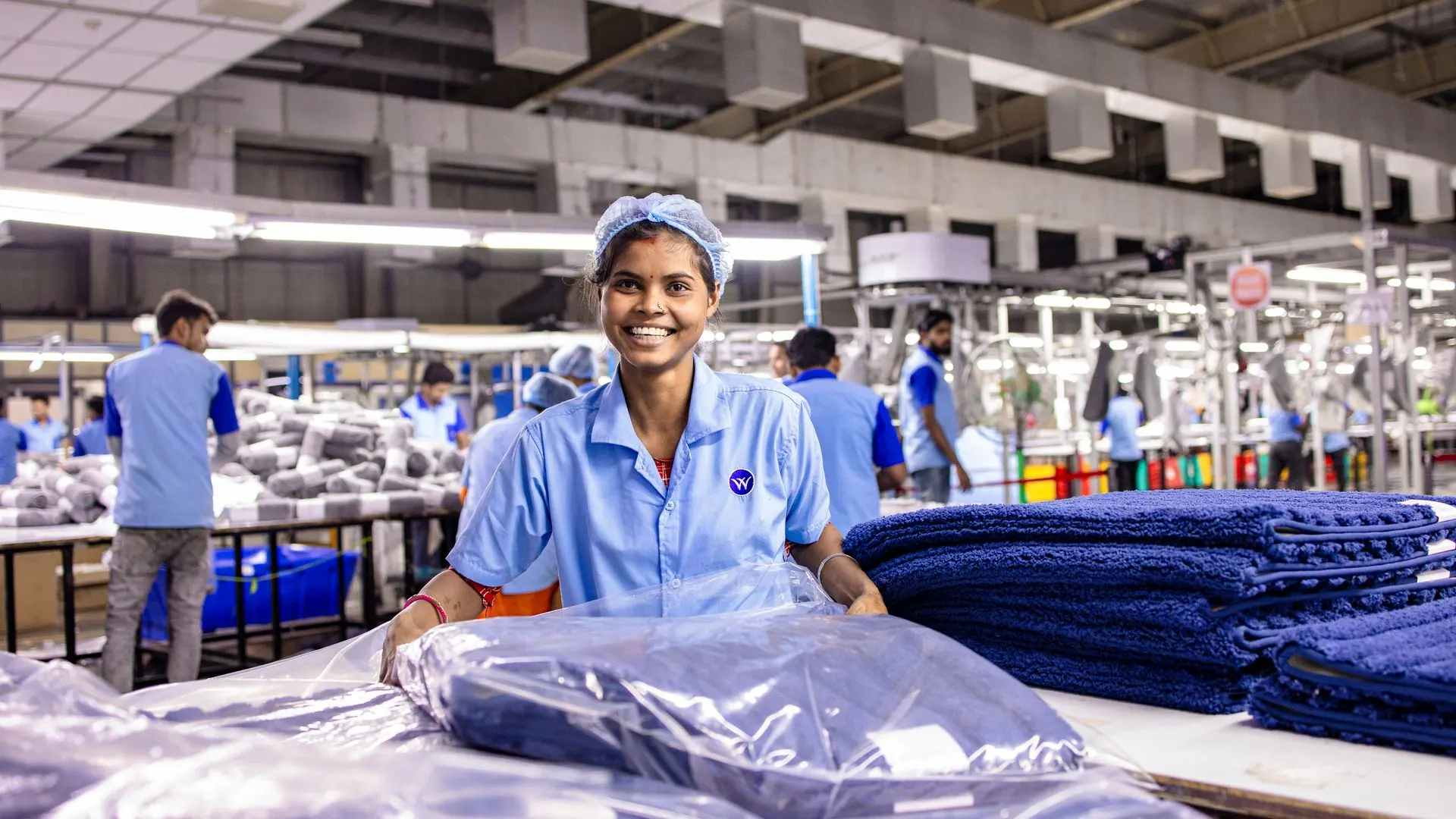 Operaria sonriendo en una planta de producción
